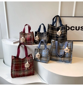 Detail of plaid wool tote bags in various colors with cute plush sheep charm