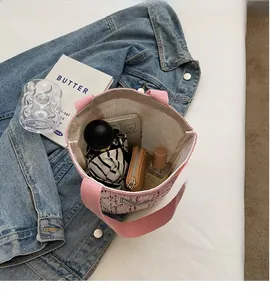 Spacious pink woven tweed bucket bag interior showing daily essentials like umbrella and phone