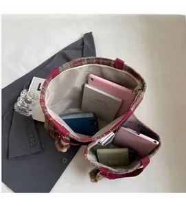 Détail de la grande capacité du sac cabas en laine à carreaux avec une tablette