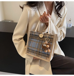 Detail of vintage blue plaid linen tote bag with rope handle and monster pendant