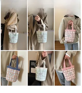 Close-up of colorful checkered linen bucket bags with woven texture and white handles