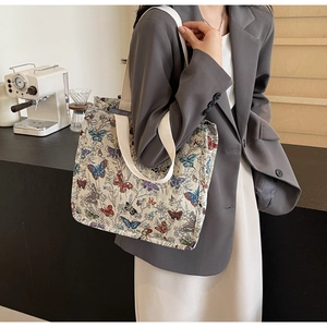 Detailed close-up of large canvas tote bag with multi-color butterfly embroidery design