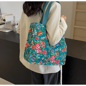 Detail of floral tote bag with peacock blue floral pattern and wide fabric strap