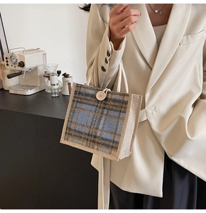 Close-up of vintage plaid linen tote bag with button closure and rustic rope handle
