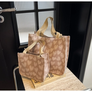 Close-up of heart pattern canvas tote bag set with nylon handles on an aesthetic background