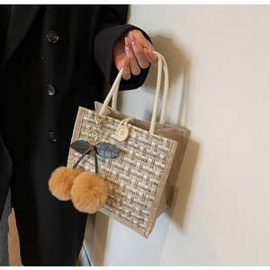 Détail du sac bento en lin avec bouton en bois et pendentif cerise en peluche