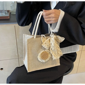 Detailed shot of linen tote with sunflower decor, lace bow and white cotton handles