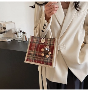 Close-up of vintage plaid linen tote with plush doll charm and cotton rope handles