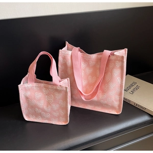 Detailed set of pink canvas tote bags with heart prints and adjustable straps