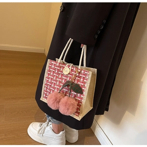 Close-up of pink tweed lunch bag with cherry charm and large button detail