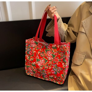 Detail of red floral tote bag with ethnic pattern and durable fabric handles