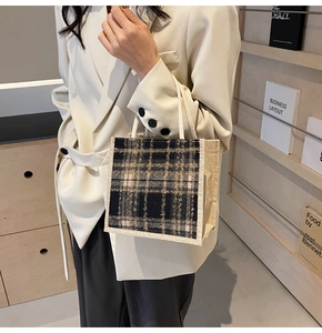 Detail of checkered woven linen tote bag held by a model in a minimalist setting