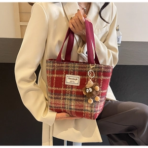 Détail du sac cabas en tweed à carreaux rouge et bleu avec charme peluche et étiquette