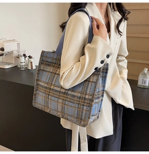 Detail of blue and brown plaid wool tote bag with textured fabric and wide handles