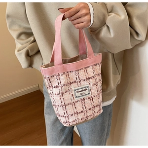 Close-up of pink and white checkered woven tote bag with soft cotton handles and texture