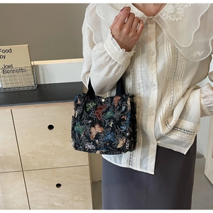 Detail of canvas tote bag with colorful butterfly embroidery and a white pearl closure