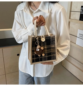 Detailed texture of plaid linen tote bag with rope handle and plush charm detail