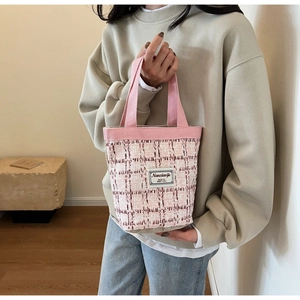 Detail of pink and white tweed woven tote bag with canvas handle and text label