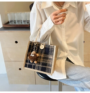 Detail of plaid linen tote bag with cotton rope handles and cute monster charm