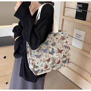 Detail of jacquard canvas tote bag with colorful butterfly patterns and wide strap