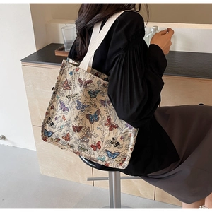 Close-up of jacquard woven tote bag with colorful butterfly patterns and white handles