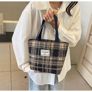 Gros plan d'un sac cabas vintage à carreaux avec texture tissée et étiquette de marque