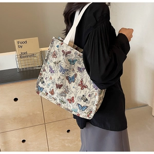 Lifestyle shot of large capacity canvas tote bag with butterfly prints on the model