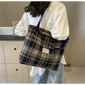 Vue portée d'un sac cabas vintage en laine à carreaux avec bandoulière bleue et étiquette