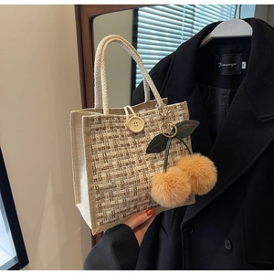 Détail du sac à bento en lin avec bouton en bois, poignée corde et décor cerise
