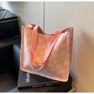 Detailed shot of pink canvas tote bag with 3D embossed hearts and matching ribbon handles