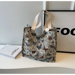 Detail of colorful butterfly jacquard embroidery on large white canvas tote bag