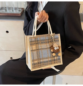 Detail of blue plaid linen handbag with white cotton rope handles and cute plush charm