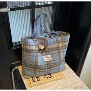 Détail du sac cabas en tweed bleu à carreaux avec breloque ours en peluche doux
