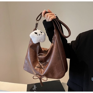 Détail du grand sac cabas marron avec laçage décoratif et breloque étoile en peluche