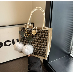 Detailed weave texture of linen lunch bag with white rope handle and cherry charm