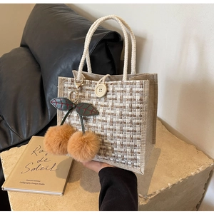 Détail du sac bento en lin avec texture mesh, anses en corde et pendentif cerise