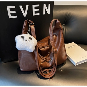 Détail d'un sac hobo marron foncé avec texture en cuir plissé et bandoulière chic