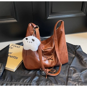 Détail du sac cabas marron vintage avec cordon de serrage et breloque étoile