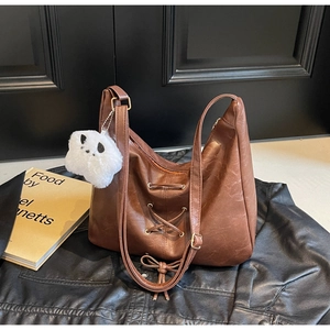 Détail du sac hobo en cuir PU marron avec laçage et charmant panda en peluche