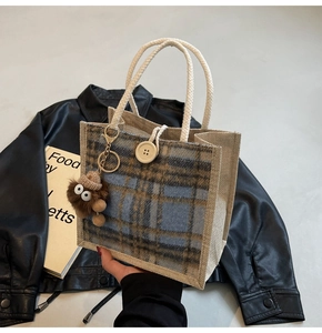 Detail of linen tote bag with plaid patchwork, rope handle and plush monster charm