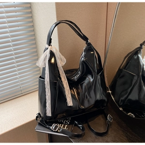 Détail du sac cabas en cuir PU noir brillant avec ruban en dentelle blanche et poche latérale
