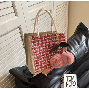 Gros plan du sac en lin avec patch en tweed rouge et breloque cerise en peluche douce