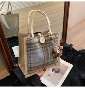 Detailed macro view of checkered woven linen tote bag featuring a cute plush bear charm