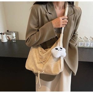 Détail du sac demi-lune crème avec lacets, nœud et charm étoile en peluche