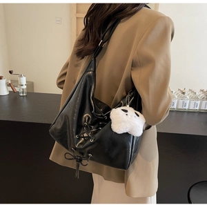 Détail du sac cabas en cuir souple noir avec lacets et pendentif fantôme en peluche