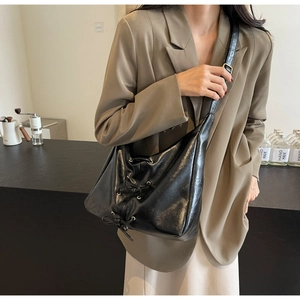 Détail du sac cabas noir avec nœuds à cordon et cuir synthétique texturé