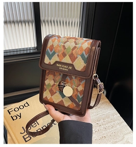 Detail of vintage woven crossbody bag with colorful diamond pattern and gold logo
