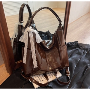 Détail du sac à main marron brillant avec gaufrage numéro 10 et nœud en dentelle