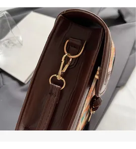 Detailed close-up of premium gold-tone metal hardware on a dark brown vintage handbag