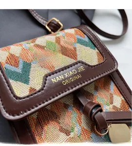 Detail of vintage woven crossbody bag featuring colorful geometric patterns and leather trim